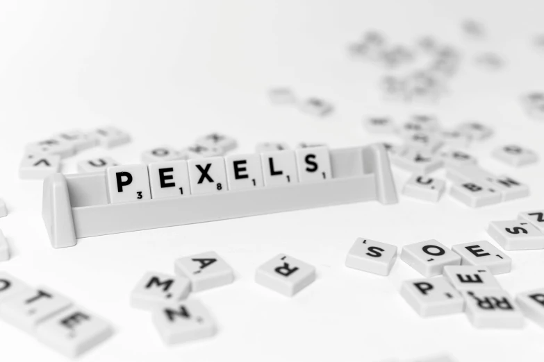 a pile of letters sitting on top of a table, an ambient occlusion render, by Daniel Lieske, pexels, pixel art, bright macro view pixar, logotype design, pimples, 1 petapixel image