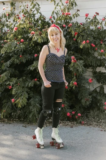 a woman standing on a skateboard in front of a bush, by Lynn Pauley, wearing a camisole, polkadots, portrait of kim petras, ( ( ( wearing jeans ) ) )