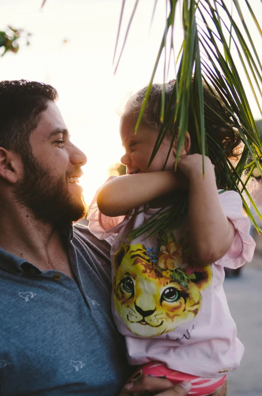 a man holding a little girl under a palm tree, justina blakeney, bearded, avatar image, zachary corzine