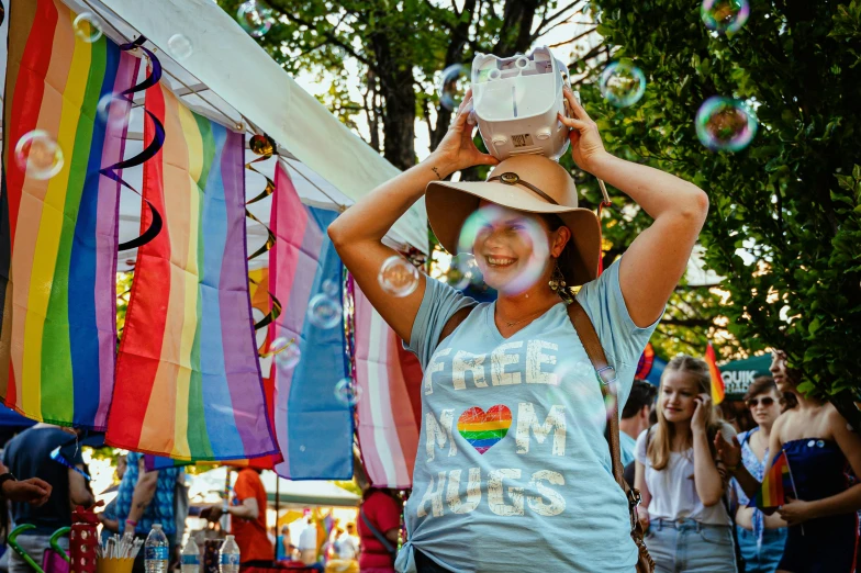 a woman standing in front of a crowd of people, by Okuda Gensō, pexels contest winner, glass bubble helmet, summer festival in background, wearing a silly hat, lesbians
