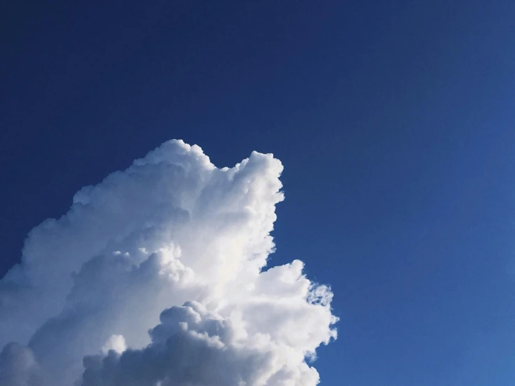 a jetliner flying through a cloudy blue sky, an album cover, unsplash, postminimalism, giant cumulonimbus cloud, ignant, white and blue, rinko kawauchi