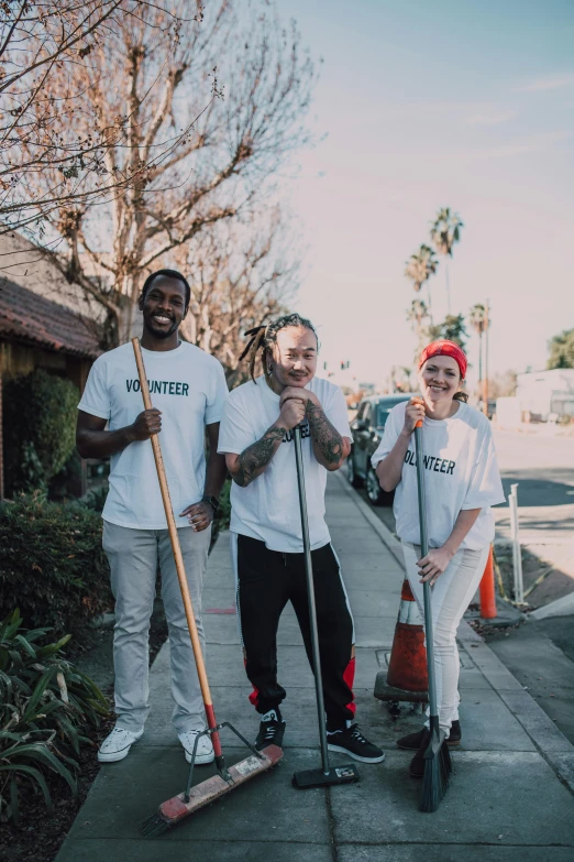 a group of people standing next to each other on a sidewalk, mac miller, cleaned up, holding a staff, jordan lamarre - wan