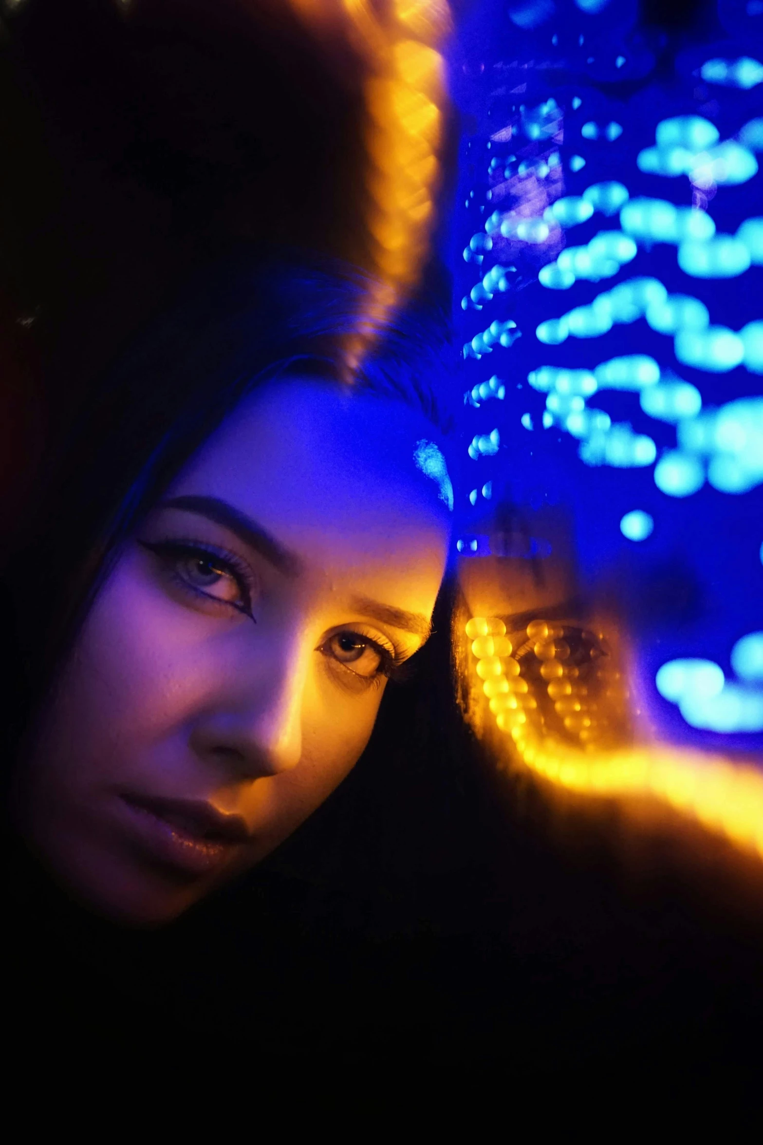 a woman looking at her reflection in a mirror, digital art, by Adam Marczyński, pexels contest winner, blue and yellow glowing lights, closeup portrait shot, glowing lights!! sci - fi, orange and blue