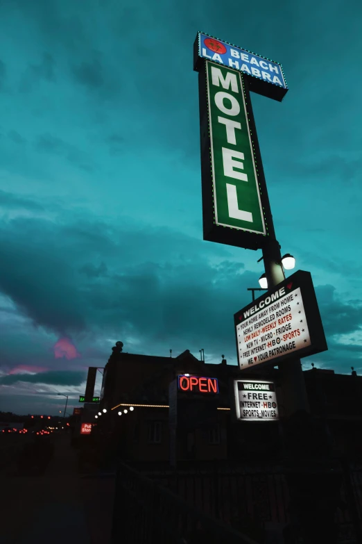 a motel sign sitting on the side of a road, poster art, unsplash, renaissance, evening lights, billboard image