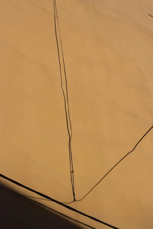 a man flying a kite on top of a sandy beach, inspired by Christo, postminimalism, ocher details, seams stitched tightly, [ overhead view of a table ]!!, skin grain detail