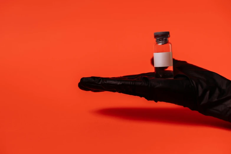a person in black gloves holding a bottle of liquid, antipodeans, vermillion, syringe, high quality image, orange and black