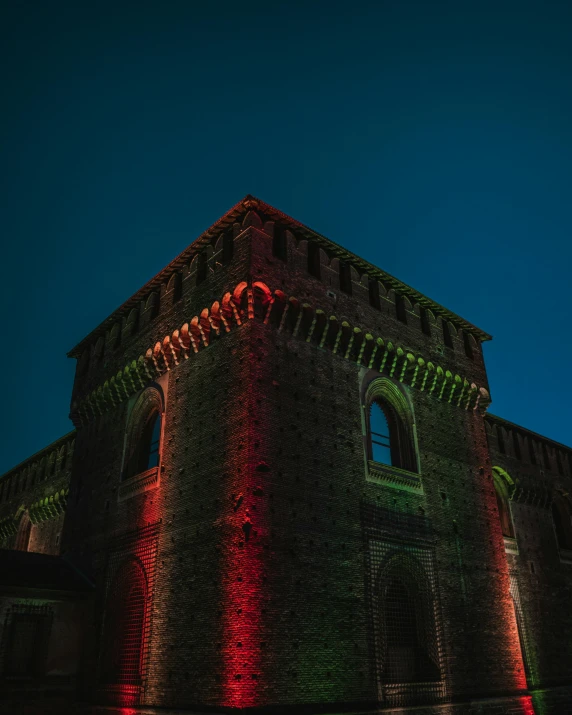 a building lit up with red and green lights, by Adam Marczyński, romanesque, rainbow lighting, old castle, high quality photo, italian masterpiece