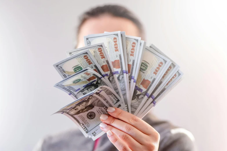 a close up of a person holding a bunch of money, profile image