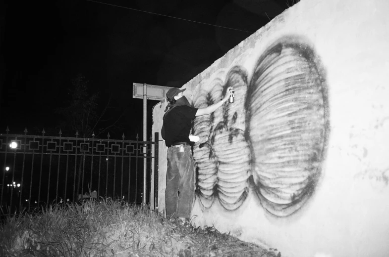 a man riding a skateboard up the side of a wall, reddit, graffiti, grainy black and white footage, night time footage, blotch of spray paint in corner, albuquerque