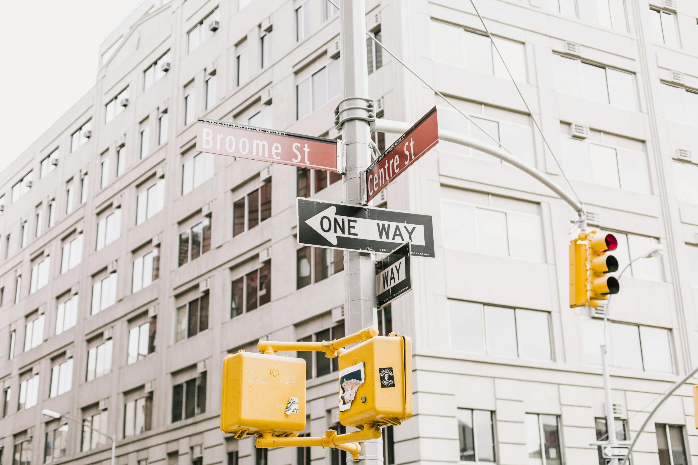 a yellow traffic light sitting next to a tall building, a photo, by Nicolette Macnamara, trending on unsplash, streets of new york, broken signs, 🚿🗝📝