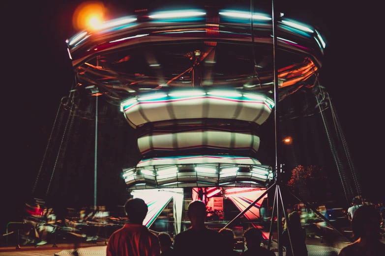 a man standing in front of a carousel at night, pexels contest winner, retrofuturism, with people inside piloting it, avatar image, instagram picture, chairlifts