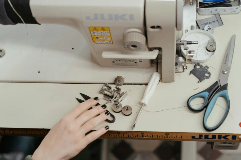 a woman is working on a sewing machine, by Julia Pishtar, trending on pexels, flat lay, 15081959 21121991 01012000 4k, metal garments, thumbnail