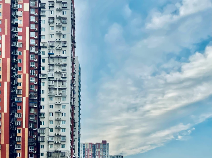 a couple of tall buildings sitting next to each other, a picture, pexels contest winner, ten flats, cloud palace, pearly sky, 2 0 2 2 photo