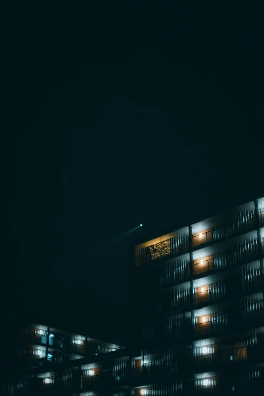 a building that is lit up at night, a photo, inspired by Elsa Bleda, unsplash, brutalism, hotel room, the moon on the top right, ✨🕌🌙, shot from afar