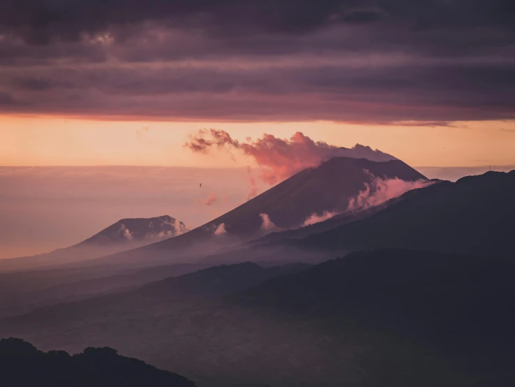 a view of a volcano from the top of a mountain, by Emma Andijewska, pexels contest winner, pink and grey clouds, humid evening, minimalistic aesthetics, multiple stories