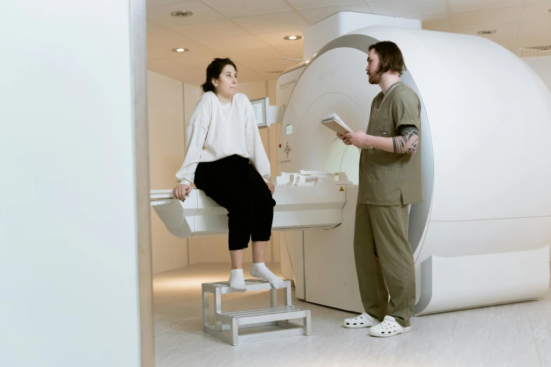 a man and a woman standing in front of a mri machine, pexels contest winner, renaissance, sitting on top a table, hi - res scan, sanja stikovic, profile image