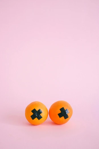 two oranges with black crosses on them, by Josse Lieferinxe, trending on pexels, conceptual art, candy decorations, nipple, jen atkin, ffffound