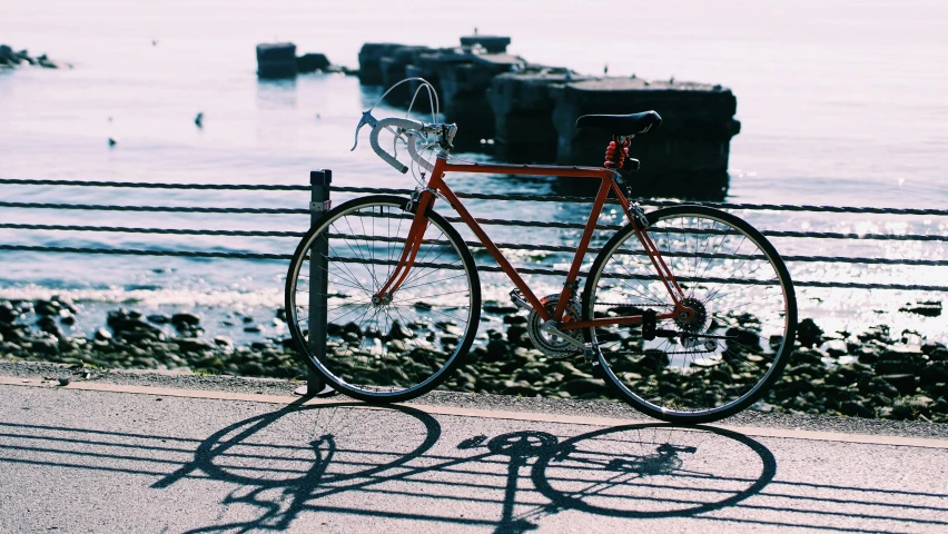 a bicycle parked on the side of a road next to a body of water, pexels contest winner, seattle, profile image, oceanside, in retro colors