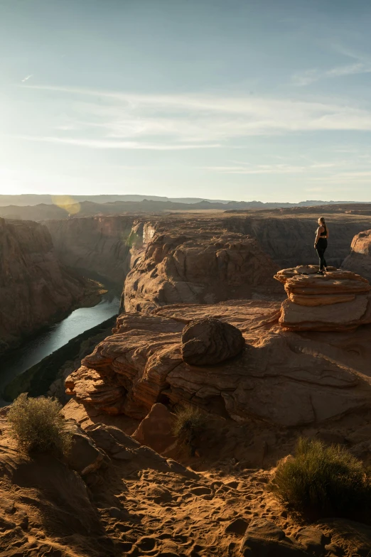 a man standing on top of a cliff next to a river, arizona desert, panoramic view of girl, 2019 trending photo