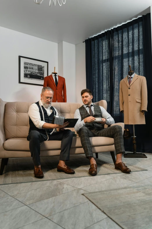 a couple of men sitting on top of a couch, inspired by Harrington Mann, pexels contest winner, suit and waistcoat, photo for a store, craftsmanship, inspect in inventory image
