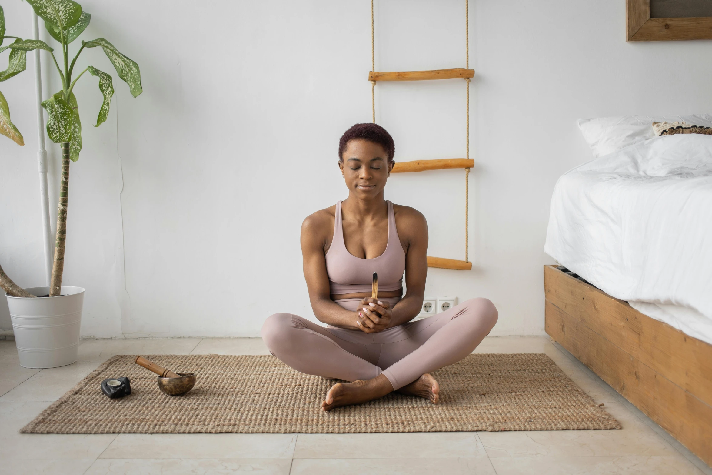 a woman sitting on the floor in a room, natural physique, healing pods, holding a wooden staff, profile image