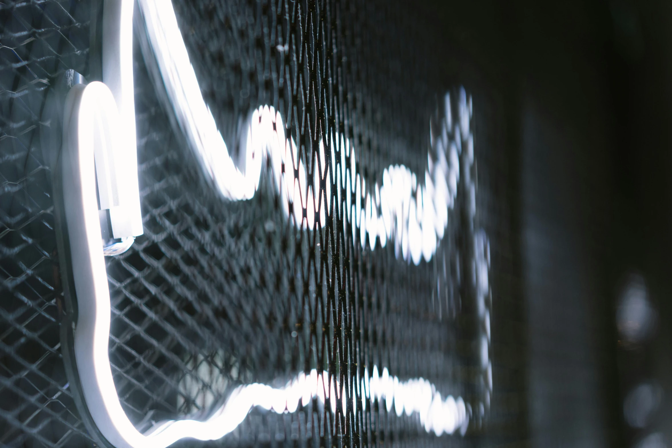 a close up of a neon sign on a wall, inspired by Bruce Nauman, unsplash, particle waves, mesh wire, monochrome, electricity lightning