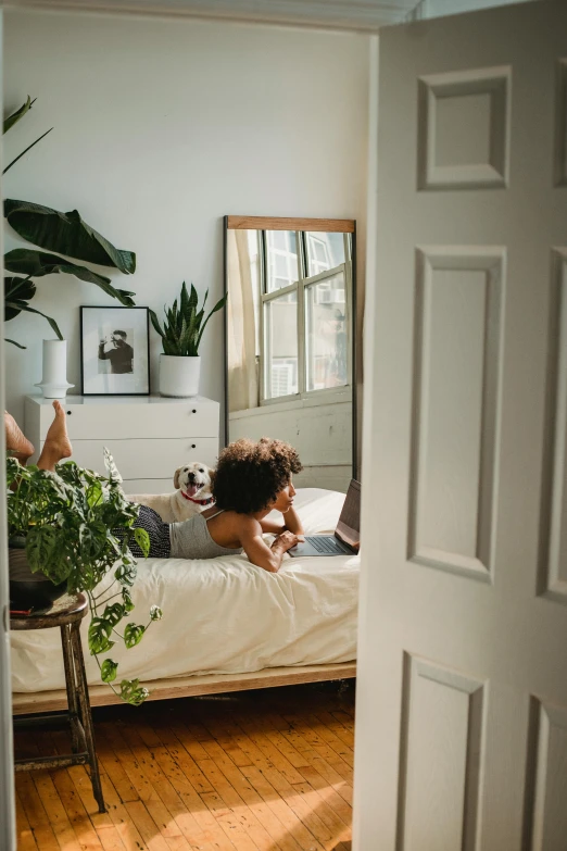 a person laying on a bed in a room, plants, profile image, dwell, doors to various bedrooms