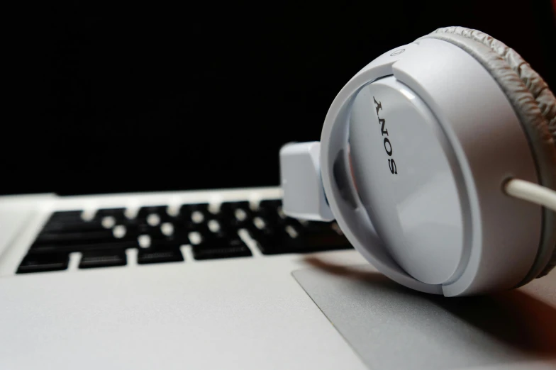 a pair of headphones sitting on top of a laptop, inspired by Oskar Lüthy, unsplash, computer art, sony a7, glossy white metal, closeup - view, modeled