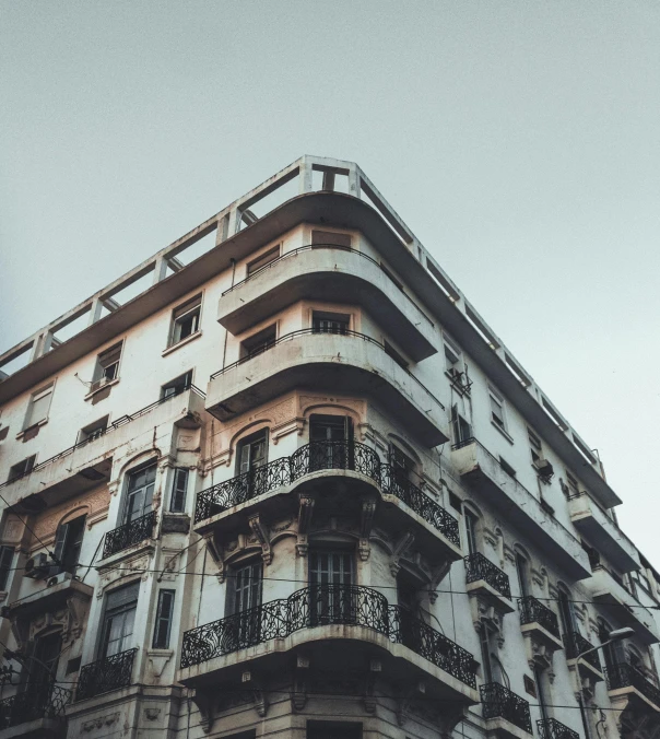 a tall building with balconies and balconies on the balconies, a photo, pexels contest winner, neoclassicism, “derelict architecture buildings, moroccan, grain”, in style of zaha hadid architect