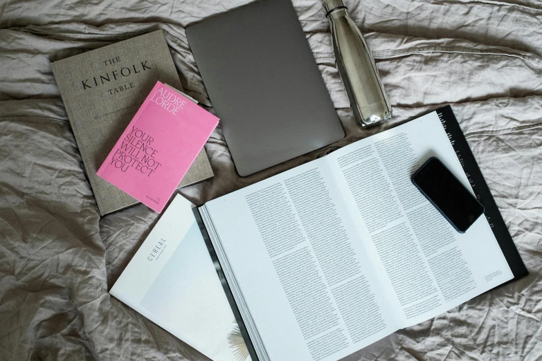 an open book sitting on top of a bed next to a laptop, a still life, unsplash, happening, asset on grey background, pink, ignant, payne's grey and venetian red