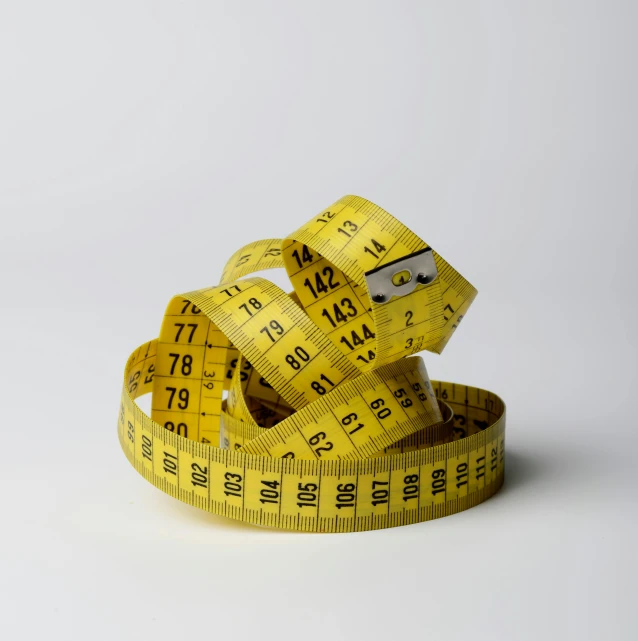 a yellow measuring tape sitting on top of a white surface, lynn skordal, large scale, 144p, high quality product