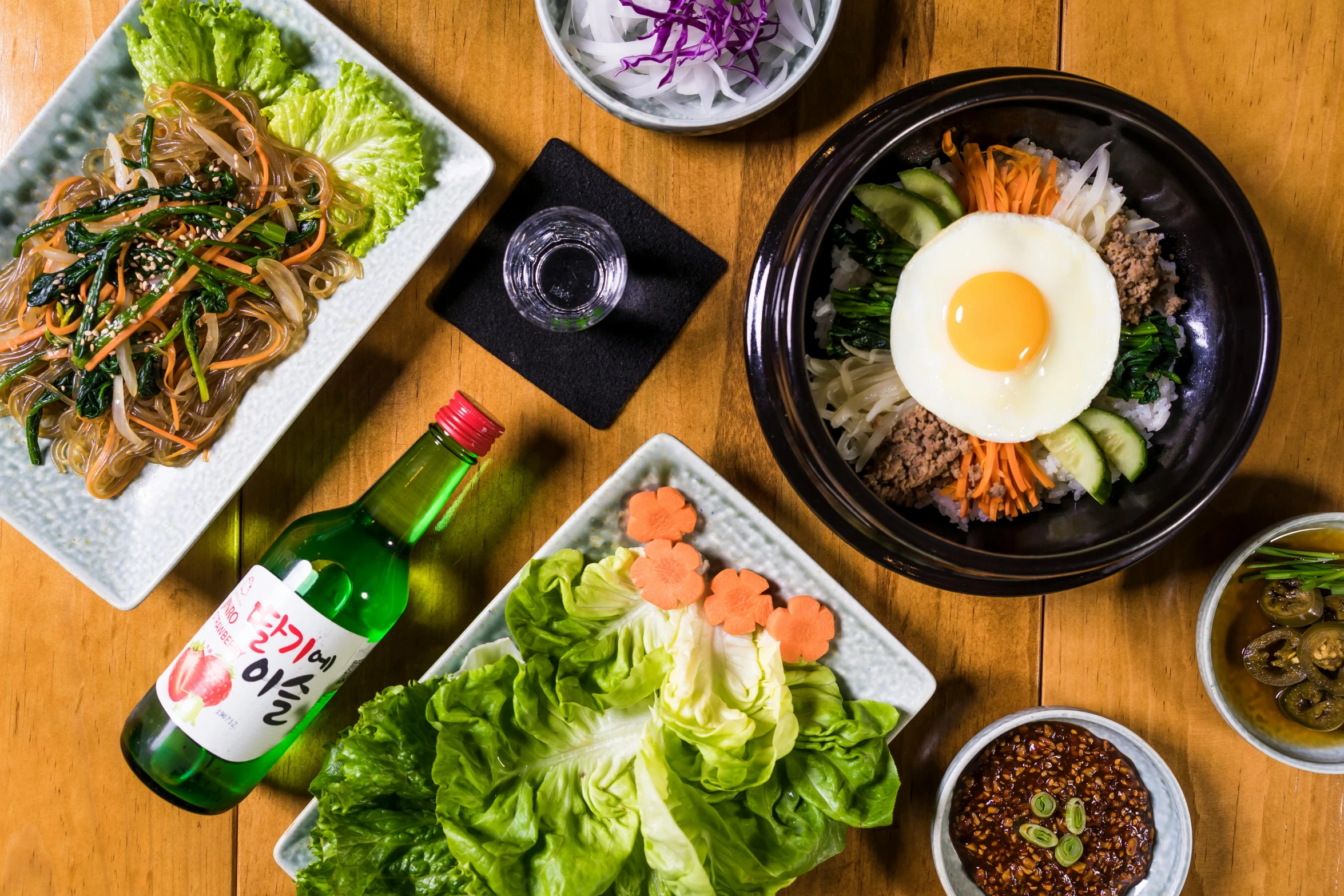 a wooden table topped with plates of food, unsplash, mingei, popular south korean makeup, drink, greens), from wheaton illinois