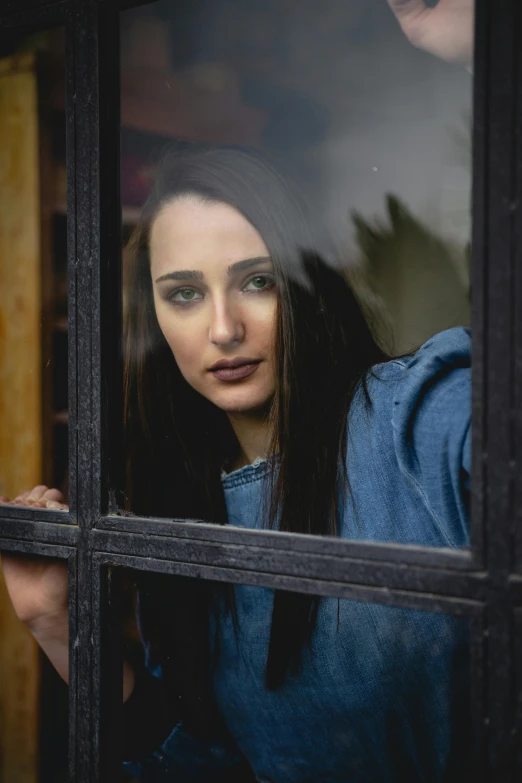 a woman is looking out of a window, a portrait, pexels contest winner, young woman with long dark hair, square, sad man, in doors