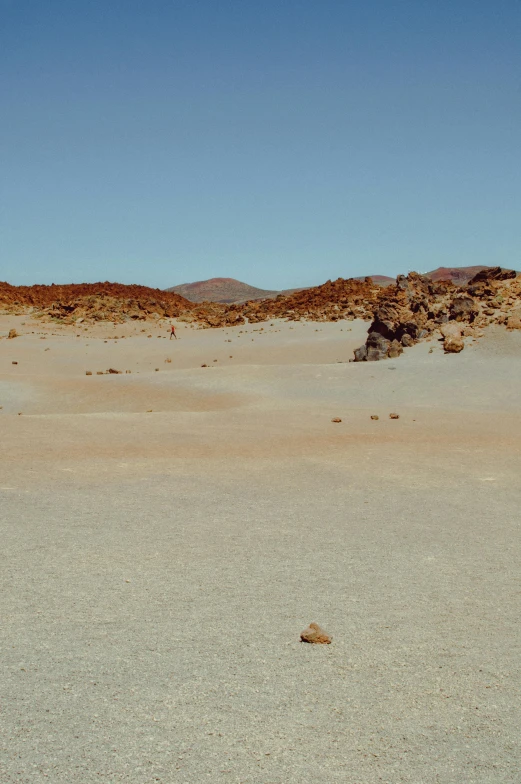 a man riding a skateboard on top of a sandy beach, a matte painting, unsplash, color field, lava field, wide panoramic shot, chile, on the moon