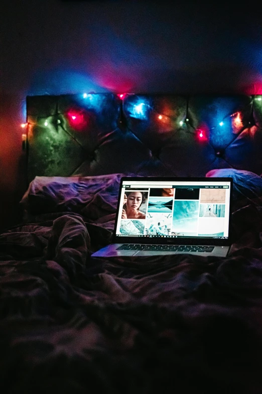 a laptop computer sitting on top of a bed, inspired by Nan Goldin, pexels, christmas lights, computer screens, hight decorated, single portrait