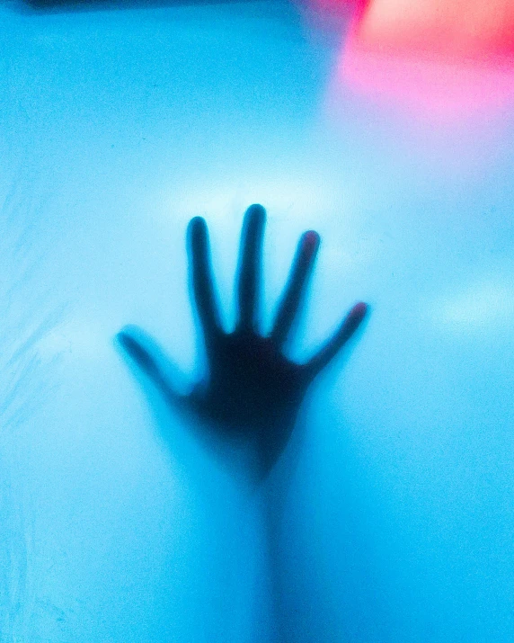 a close up of a person's hand with a blurry background, a hologram, pexels contest winner, transgressive art, bathing in light, blue image, album cover, horrified