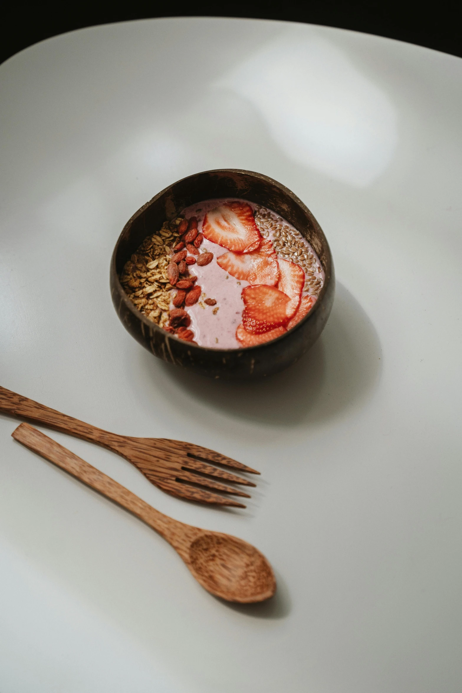 a bowl of oatmeal with strawberries and two wooden spoons, unsplash, hurufiyya, bali, bronze, made of glazed, photo of a model