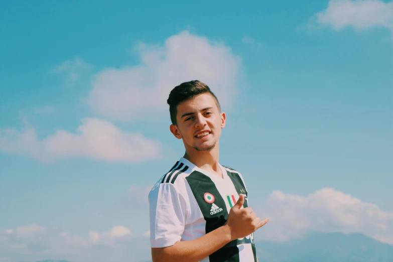 a man standing on top of a sandy beach, an album cover, inspired by Ion Andreescu, on a soccer field, while smiling for a photograph, profile image, shot with sony alpha