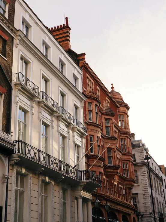 a row of buildings on a city street, inspired by Christopher Wren, pexels contest winner, art nouveau, profile image, balcony, london, payne's grey and venetian red