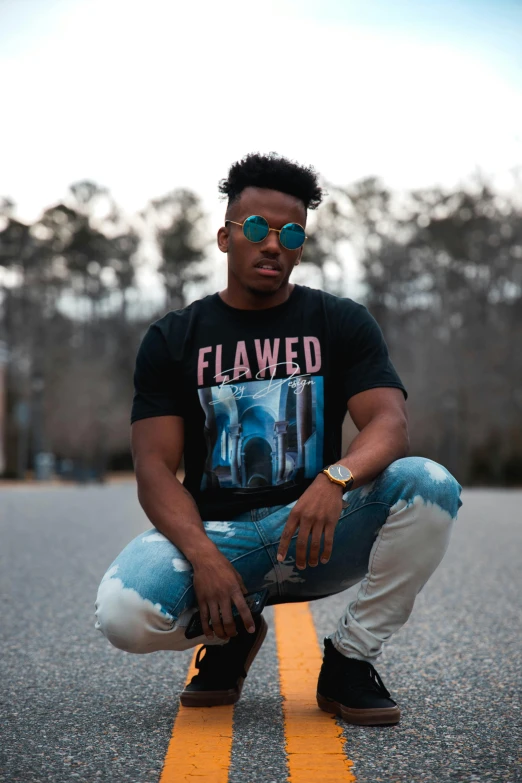 a man squatting in the middle of the road, an album cover, inspired by Terrell James, pexels contest winner, flawless beauty, graphic tees, blue flame, wearing a shirt