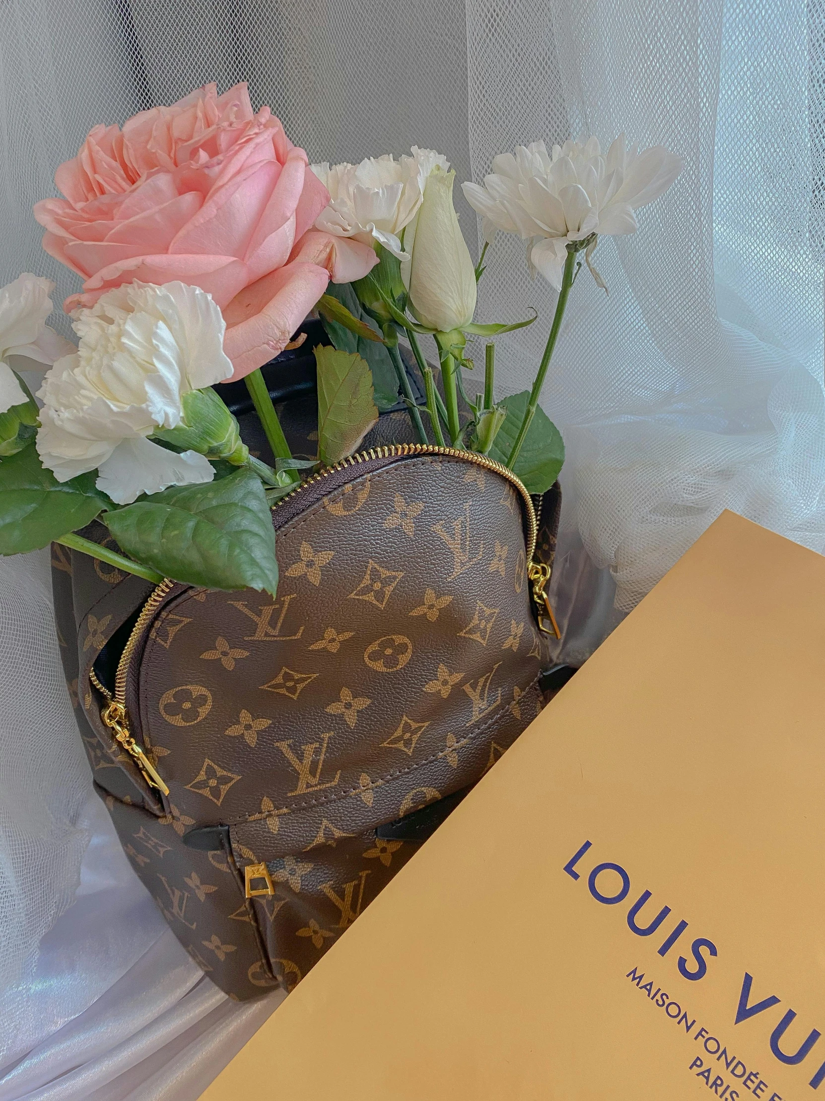 a book sitting on top of a table next to a vase of flowers, inspired by Louis Hersent, instagram contest winner, wearing louis vuitton armor, with great domes and arches, holding a gold bag, 中 元 节