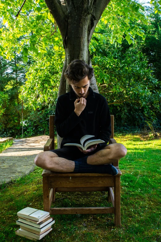 a man sitting in a chair reading a book, pexels contest winner, sitting in the garden, avatar image, thinker pose, profile picture