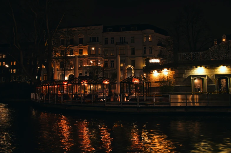 a boat that is sitting in the water, by Emma Andijewska, pexels contest winner, art nouveau, taverns nighttime lifestyle, kreuzberg, moody : : wes anderson, paris hotel style