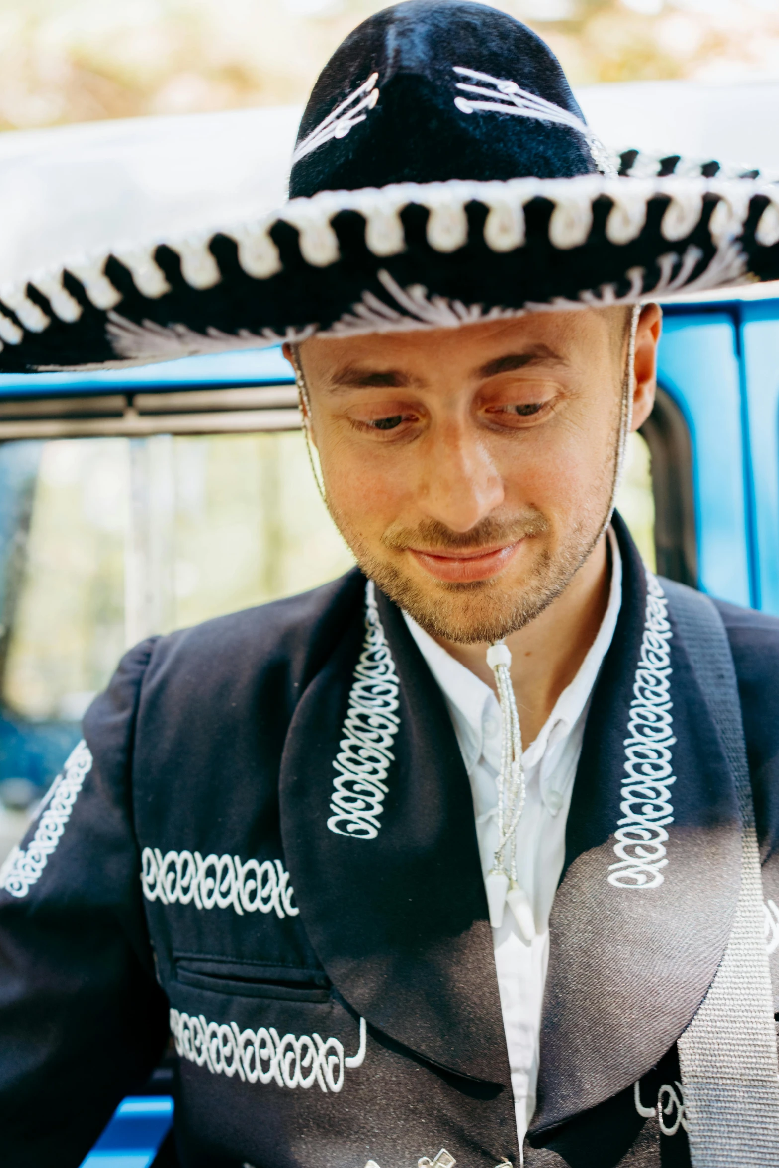a man wearing a sombren standing in front of a blue car, an album cover, inspired by Germán Londoño, sombrero, daniel radcliffe, profile image, wearing authentic attire