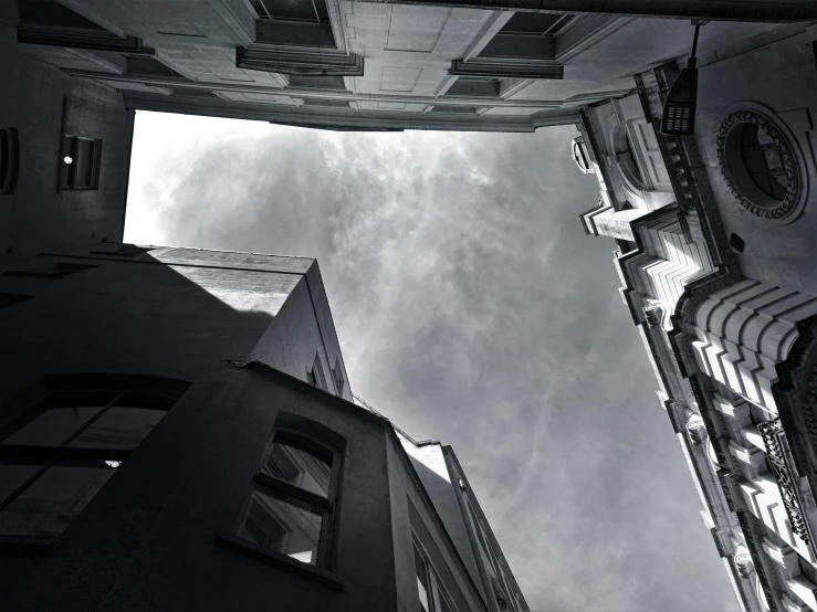 a black and white photo of a very tall building, pexels contest winner, conceptual art, impending doom in an alleyway, sky view, volumetric godrays, instagram picture