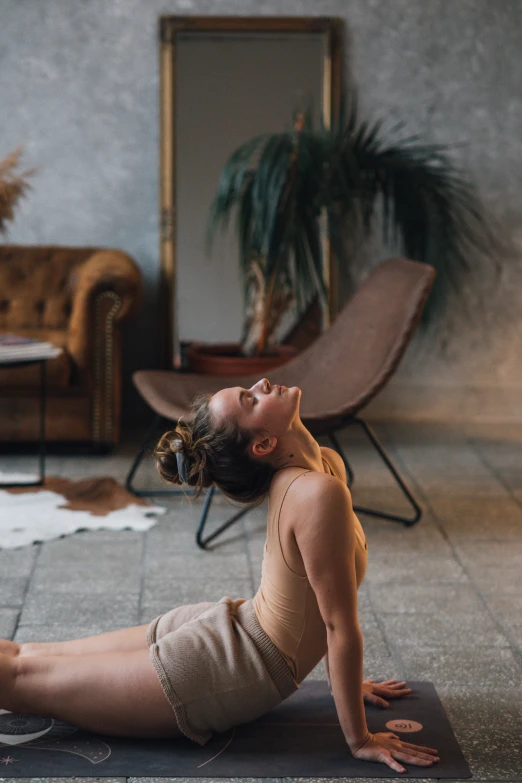 a woman doing a yoga pose in a living room, by Emma Andijewska, renaissance, spa, head tilted down, ocher, chill