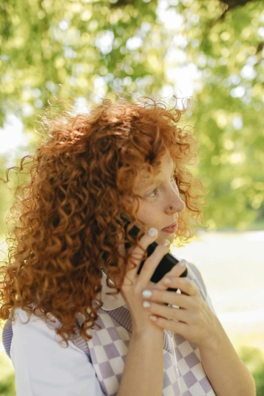 a woman with red hair talking on a cell phone, trending on pexels, renaissance, curly, warm weather, square, holding microphone