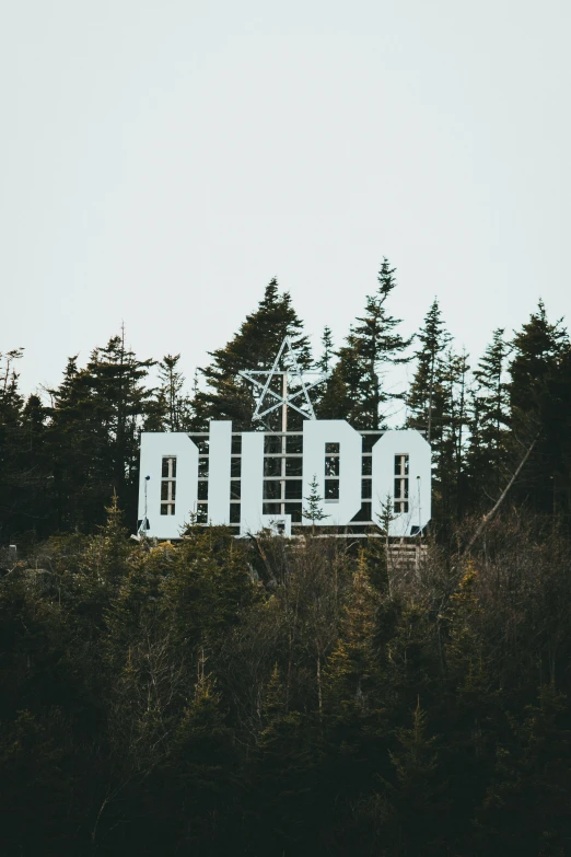 a white sign sitting on top of a lush green hillside, inspired by Elsa Bleda, trending on unsplash, graffiti, dio, oil rig, 000 — википедия, diablo