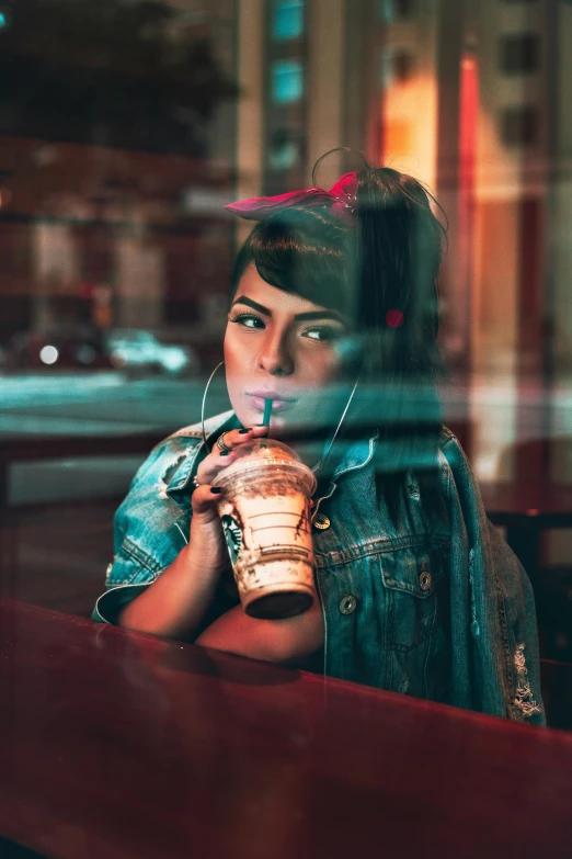 a woman sitting at a table drinking a drink, a picture, inspired by Elsa Bleda, trending on pexels, hyperrealism, flashing lights, starbucks, cinematic outfit photo, 80s photo
