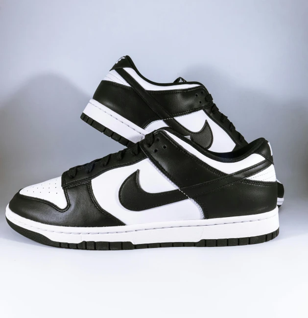 a pair of black and white sneakers, ultra - high jump, nike logo, 2263539546], a wide full shot